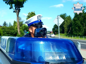 Policjant ruchu drogowego dokuje pomiaru prędkości kierujących.