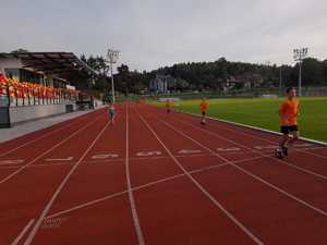 Zawodnicy klubu sportowgo biegną na bieżni