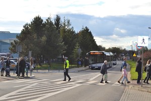 Policjant ruchu drogowego reguluje ruchem na skrzyżowaniu w rejonie cmentarza